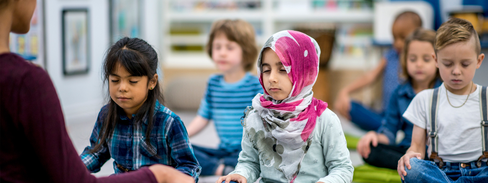 young children practicing breathing and relaxing techniques in classroom